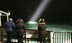 Des personnes à bord d'un bateau qui participaient aux recherches d'un hélicoptère disparu dans l'Arctique, le 26 octobre 2017 