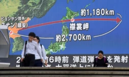 Des passants devant un écran géant à Tokyo montrant le trajectoire du missile nord-coréen, le 29 août 2017