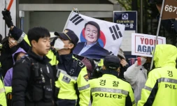 Des policiers attendent l'arrivée de l'ancien président sud-coréen Yoon Suk Yeol devant le tribunal deSéoul, le 14 avril 2025, face à des partisans de Yoon