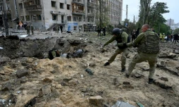 Des soldats retirent un fragment de missile dans un cratĂšre aprĂšs une frappe Ă Kharkiv, le 6 octobre 2023 dans l'est de l'Ukraine