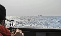 Un marin taĂŻwanais observe le porte-avions chinois Shandong Ă l'est de TaĂŻwan, le 5 avril 2023