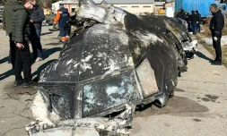 Une photo obtenue et diffusée le 11 janvier 2020 par le Conseil de la défense et de la sécurité nationales d'Ukraine, montre des experts autour des débris de l'avion ukrainien abattu "par erreur" par l'Iran après son décollage de Téhéran le 8 janvier 2020