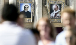 Portraits de l'archevêque salvadorien Oscar Romero (g) et du pape Paul VI (d) sur la façade de la Basilique Saint-Pierre, au Vatican, le 13 octobre 2018