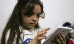 La petite Syrienne Bana al-Abed regarde son compte Twitter sur un smartphone, le 12 octobre 2016 à Alep-est
