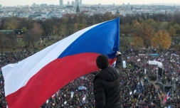 Un homme brandit un drapeau tchèque au-dessus d'une foule de manifestants lors d'un rassemblement contre le Premier ministre tchèque Andrej Babis, à la veille de l'anniversaire de la Révolution de velours, à Prague, le 16 novembre 2019