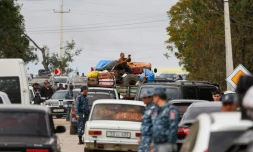 Des policiers arméniens marchent parmi le flot de voitures de réfugiés venus du Nagorny Karabakh, près de la ville frontière de Kornidzor, le 26 septembre 26 2023.