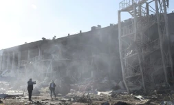 Des personnes prennent des photos devant les ruines d'un centre commercial et de loisirs touché par des missiles russes, à Odessa, le 10 mai 2022