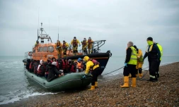 Des migrants à bord d'un canot de la RNLI arrivent sur la plage de Dungeness, le 24 novembre 2021, dans le sud-est de l'Angleterre, aprÚs avoir été secourus dans la Manche