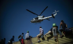 Des migrants centraméricains grimpent sur la barriÚre métallique qui délimite la frontiÚre entre le Mexique et les Etats-Unis à Tijuana, le 25 novembre 2018