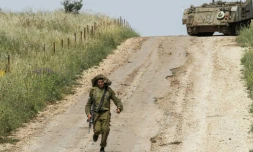 Un soldat israélien court sur une route située le long de la frontière syrienne, sur la partie du plateau du Golan occupée par Israël, le 10 mai 2018