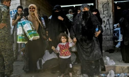 Des femmes et des enfants syriens se rassemblent à l'ouest de Raqa après avoir fui le centre de la ville pour échapper à l'EI, le 12 octobre 2017