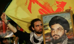 Des hommes brandissent des drapeaux du Hezbollah et des portraits du chef du groupe Hassan Nasrallah dans une banlieue sud de Beyrouth le 11 septembre 2006
