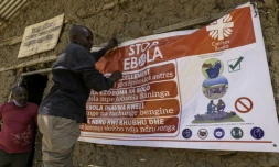 Un homme accroche une affiche de sensibilisation dans la lutte contre le virus Ebola, le 28 mai 2026 à Bunia, dans l'est de la République démocratique du Congo (RDC)