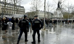 Des policiers regardent quelques centaines de personnes se rassemblaient place de la République pour une assemblée générale du mouvement "Nuit debout", à Paris le 11 avril 2016