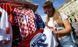 Une supportrice achète un maillot de football aux couleurs de la Croatie à la veille de la finale du Mondial-2018 contre la France, le 14 juillet 2018 à Zagreb 