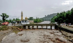 Des villageois (d) se tiennent près d'un pont alors que le niveau des eaux de crue monte dans le district de Buner, dans la province  de Khyber Pakhtunkhwa, le 18 août 2025 au Pakistan