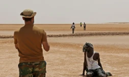 Un garde-frontiÚre libyen observe des migrants africains dans le désert, prÚs d' Al'Assah, à la frontiÚre entre la Libye et la Tunisie, le 30 juillet 2023