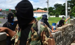 Des étudiants munis d'armes artisanales derrière une barricade, le 23 juin 2018 à Managua, au Nicaragua