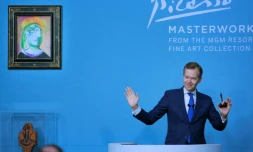 Oliver Barker, commissaire-priseur de Sotheby's, lors d'une vente aux enchères de 11 oeuvres de Picasso provenant de la collection de MGM Resorts dont la "Femme au béret rouge-orange" (en haut à g), le 23 octobre 2021 à Las Vegas 