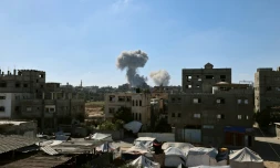De la fumée s'élève en arrière-plan lors d'une frappe israélienne dans le centre de la bande de Gaza, le 29 mai 2025