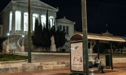 Une femme porte un masque de protection dans un arrêt de bus dans le centre d'Athènes, en Grèce, où le gouvernement a prolongé le confinement et durci les restrictions contre la pandémie, le 3 mars 2021