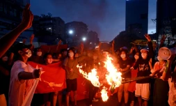 Des protestataires brûlent des drapeaux birmans lors d'une manifestation contre la junte à Rangoun le 29 juillet 2021