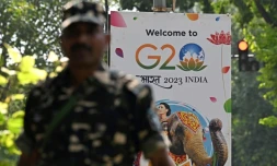 Un agent de sécurité monte la garde à cÎté d'une pancarte installée dans une rue de New Delhi avant le sommet de deux jours du G20, le 5 septembre 2023
