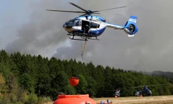 Des hĂ©licoptĂšres de la police chargent de l'eau pour lutter contre un incendie de forĂȘt Ă Hurtgenwald, dans l'ouest de l'Allemagne, le 14 aoĂ»t 2026