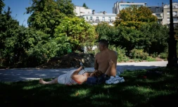 Des personnes sont allongées sur l'herbe à l'ombre place de la Nation, à Paris, le 28 juillet 2026, lors de la quatrième vague de chaleur en France