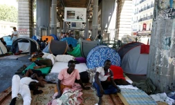 Des migrants dans le campement improvisé sous la station de métro Jean JaurÚs à Paris le 19 juillet 2016