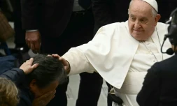 Le pape François touche la tête d'un homme, le 14 décembre 2024 à la salle Paul-VI au Vatican