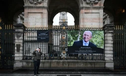 Un panneau d'information pour les personnes souhaitant rendre hommage à Gérard Collomb et un portrait de l'ex-maire de Lyon et ancien ministre de l'Intérieur sont affichés devant l'hÎtel de ville de Lyon, le 27 novembre 2023