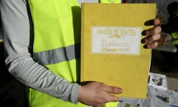 Un "gilet jaune" montre le cahier de doléances qu'il présente sur un rond-point à Cagnes-sur-mer, le 20 décembre 2018