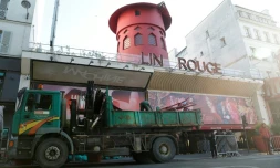 Des ouvriers sécurisent la zone devant le Moulin Rouge à Paris aprÚs que ses ailes et des lettres de la façade sont tombées dans la nuit sans faire de blessés, le 25 avril 2024