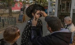 Volodymyr maquille pour Halloween le visage de sa fille Daria, le 31 octobre 2023 à Kherson, en Ukraine