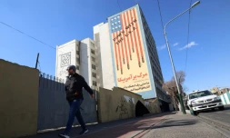 Un Iranien passe devant une immense fresque anti-américaine peinte sur un bâtiment dans la capitale iranienne, Téhéran, le 31 janvier 2026