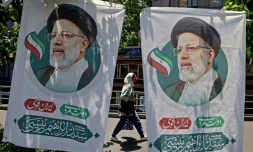 Une Iranienne passe entre deux affiches du candidat à la présidentielle Ebrahim Raisi, à Téhéran le 17 juin 2021