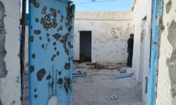 Un homme inspecte une maison à Benniri, au sud de la ville tunisienne de Ben Guerdane théùtre d'accrochages entre jihadistes et militaires, le 9 mars 2016