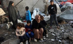 Des habitants de Gaza dans les ruines d'une école abritant des déplacés touchée par une frappe israélienne, à Gaza-ville le 15 janvier 2025