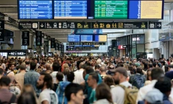 Des passagers autour des panneaux de départ et d'arrivée à la gare Montparnasse à Paris le 26 juillet 2024