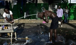 Des migrants se lavent à la Porte de la Chapelle à Paris, le 29 juin 2017