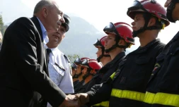Le ministre de l'Intérieur Gérard Collomb (g) salue des pompiers, le 5 août 2017 à Palneca en Corse-du-Sud