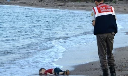 Un officier turc s'approche du corps d'Aylan Kurdi, un enfant syrien retrouvé mort sur une plage de Bodrum, en Turquie, le 2 septembre 2015 