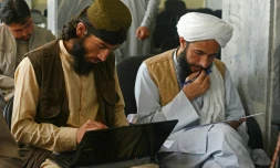 Le taliban Gul Agha Jalali (g) suit un cours d'informatique dans une salle du ministère des Transports, le 5 juin 2022 à Kaboul, en Afghanistan
