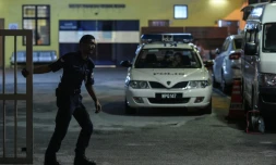 Un policier referme la barrière d'accès au bâtiment de médecine légale de l'hôpital de Kuala Lumpur où se trouve le corps de Kim Jong-Nam, demi-frère du leader nord-coréen Kim Jong-Un, le 27 février 2017 en Malaisie
