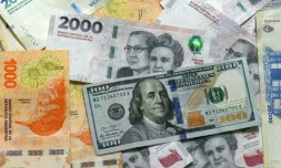 Des billets de pesos argentines et un billet de 100 dollars, le 11 avril 2025 à Buenos Aires