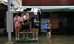 Des habitants sur un banc dans une rue de Bangkok, où l'état de catastrophe naturelle a été déclaré après des pluies diluviennes qui ont inondé habitations, commerces et axes de circulation, le 27 septembre 2026