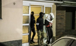 La police allemande escorte une personne arrêtée à Hagen, dans l'ouest de l'Allemagne, le 3 mai 2023, dans le cadre d'une opération contre la mafia italienne 'Ndrangheta