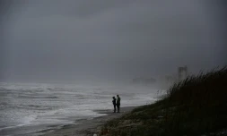 Des américains sur la plage de Jacksonville balayée par des vents et des pluies avant l'arrivée de l'ouragan Matthew, le 6 octobre 2016 en Floride