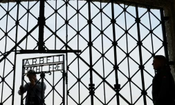 Des ouvriers fixent la réplique du portail portant l'inscription "Arbeit macht frei" de l'ancien camp de concentration de Dachau, dans le sud de l'Allemagne, le 29 avril 2015